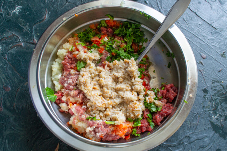 Migas de pan en la carne Agregando pan blanco remojado a un tazón con carne molida
