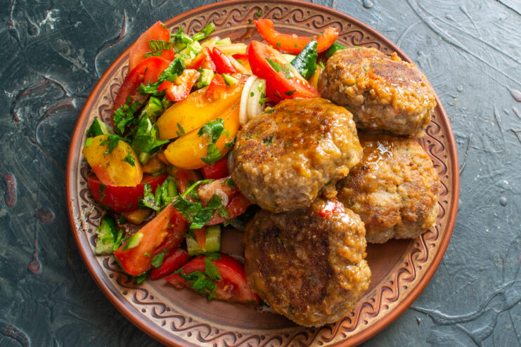Presentación del plato Albóndigas de res preparadas con guarnición de vegetales frescos en un plato