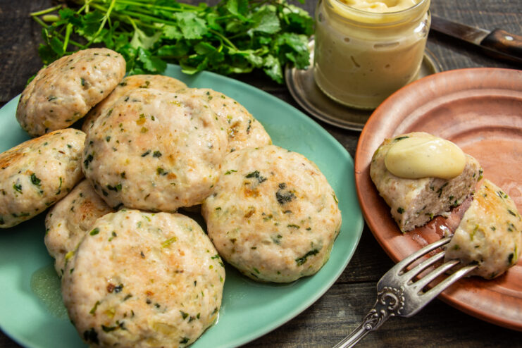Tortitas de pollo con cilantro servidas en un plato con salsa