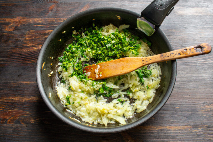 Cebolla y cilantro para la carne Cebolla sofrita con cilantro fresco en una sartén