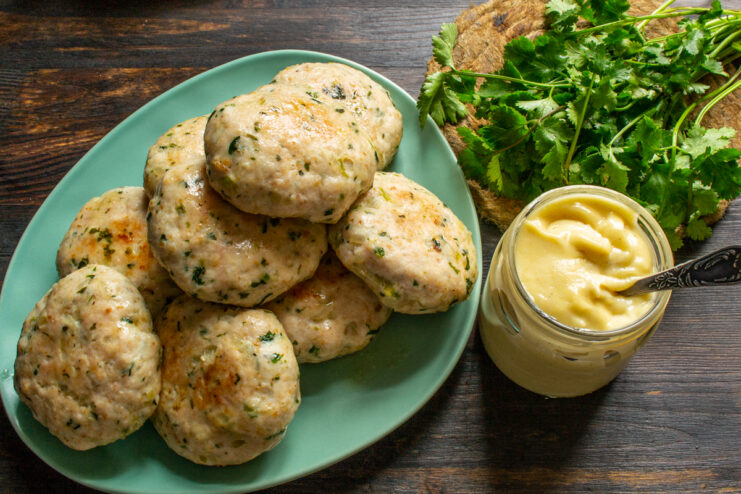 Servicio del plato Plato de tortitas de pollo decorado con hierbas frescas y salsa