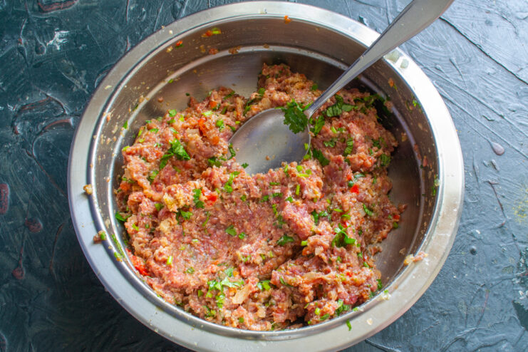 Mezcla lista para formar Carne molida bien amasada con especias y hierbas en un tazón