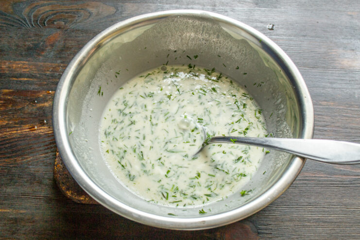 Salsa de crema con eneldo Salsa de crema blanca con hierbas en un tazón