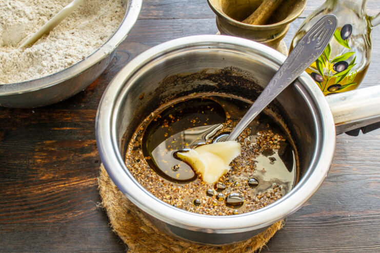 Miel para la masa Añadiendo miel a la mezcla tibia de ingredientes en la cacerola