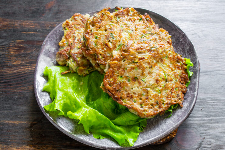 Tortitas de zucchini servidas sobre lechuga fresca