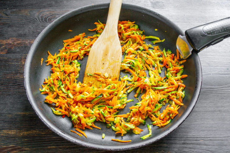 Base de vegetales para el paté Vegetales guisados y suaves cocinándose en una sartén a fuego medio