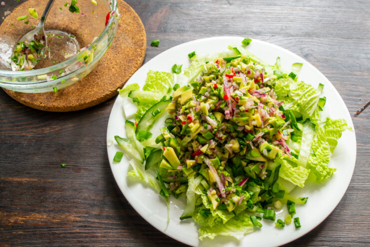 Montaje final de la ensalada Guacamole colocado en el centro de la base de vegetales