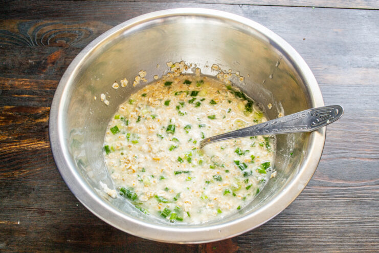 Adición de kéfir Vertiendo kéfir en el tazón con la mezcla de avena y queso