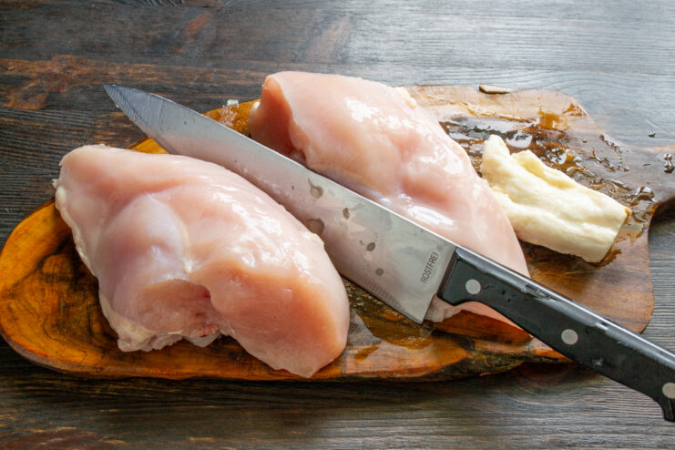 Preparación de la carne de pollo Pechuga de pollo y grasa de cerdo sobre una tabla de cortar