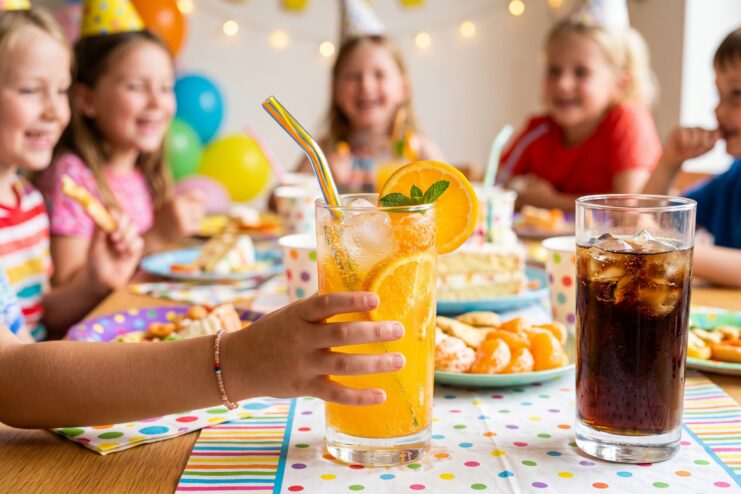 Limonada casera de naranja en fiesta infantil Niño eligiendo una limonada casera brillante con naranja en lugar de un refresco de cola en un cumpleaños