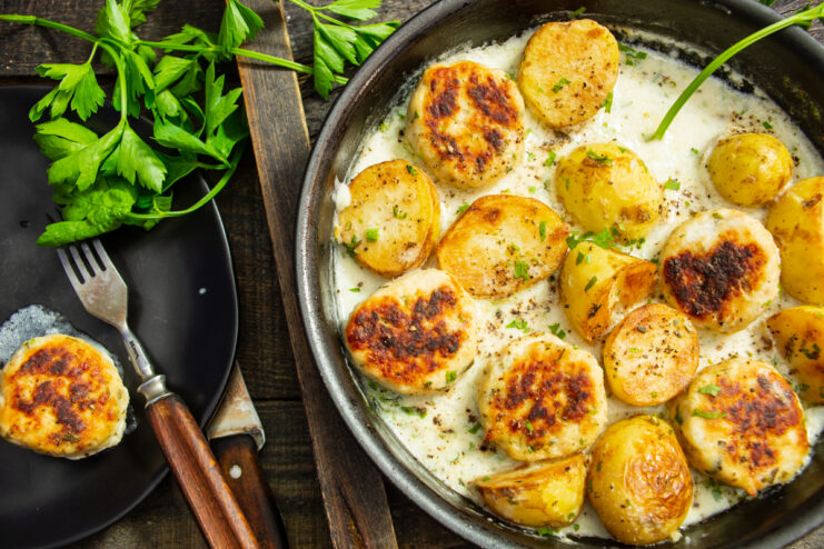 Papas nuevas con albóndigas servidas en salsa cremosa