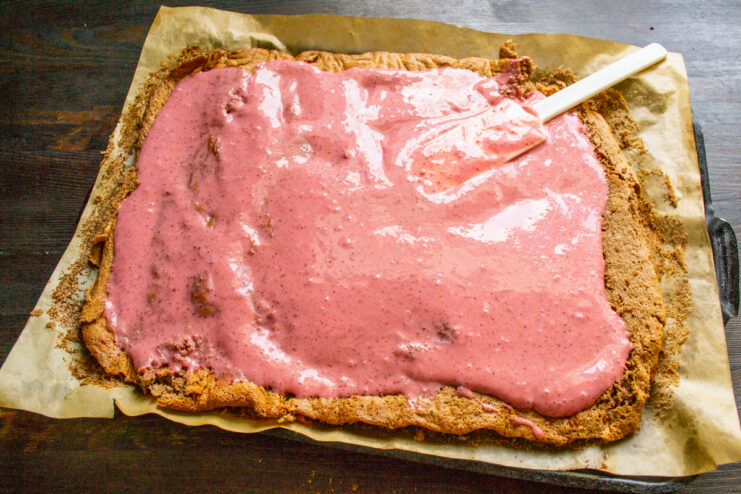Relleno del pastel con crema Aplicación de crema de fresa sobre el bizcocho desenrollado