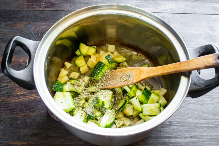 Zucchini y hierbas aromáticas Trozos de zucchini y hierbas secas agregados a la olla con papa y cebolla.