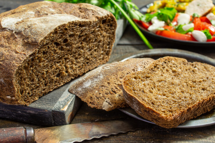 Pan de centeno de masa madre rebanado sobre una tabla de madera