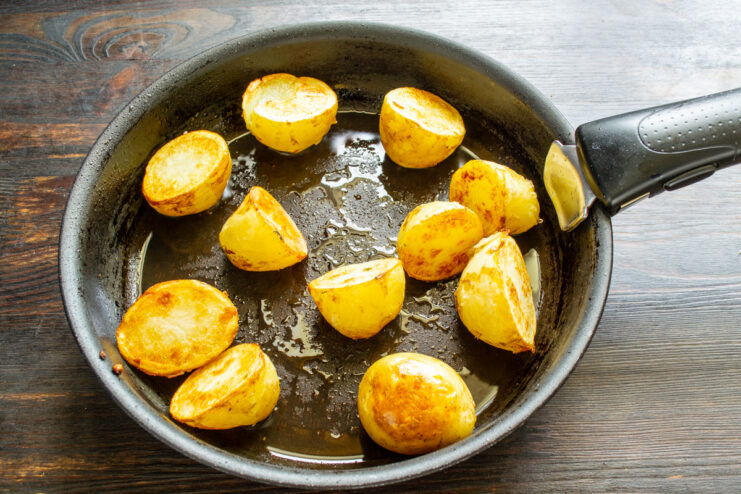 Papas doradas en la sartén Papas nuevas doradas y crujientes en una sartén