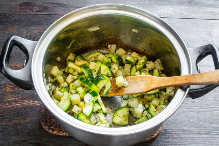Sofrito de las verduras con especias Verduras mezcladas con especias y aceite de oliva sofriéndose en una olla.