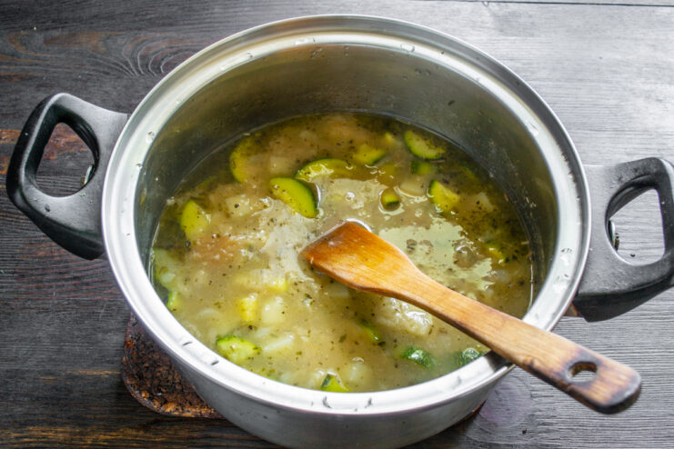 Cocción de las verduras Verduras cocinándose a fuego lento dentro de una olla en la estufa.