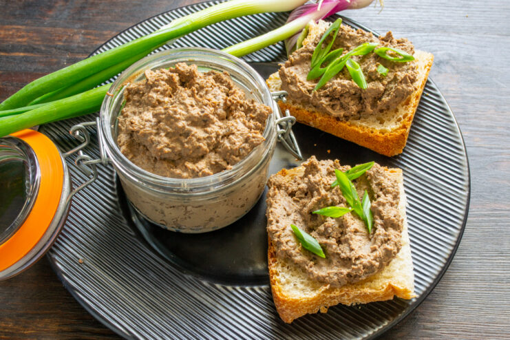 Paté almacenado en recipiente de vidrio y decorado con hierbas