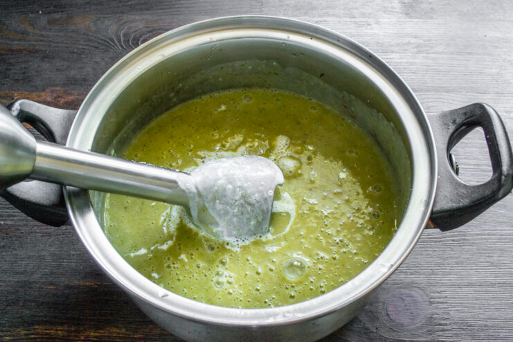 Triturado de la sopa con licuadora Licuadora de inmersión procesando las verduras cocidas en la olla para hacer una crema.