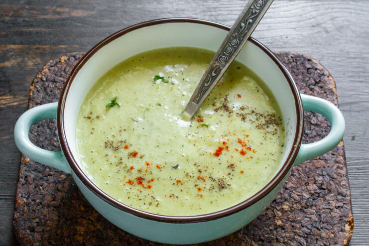 Emplatado y decoración de la sopa Plato de crema de zucchini espolvoreada con especias rojas y negras.
