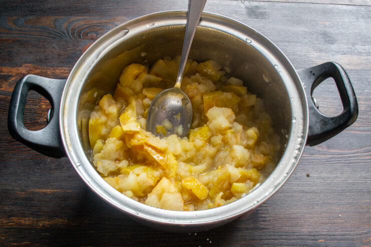 Cocción de las manzanas Manzanas cocidas y reblandecidas dentro de una olla metálica.