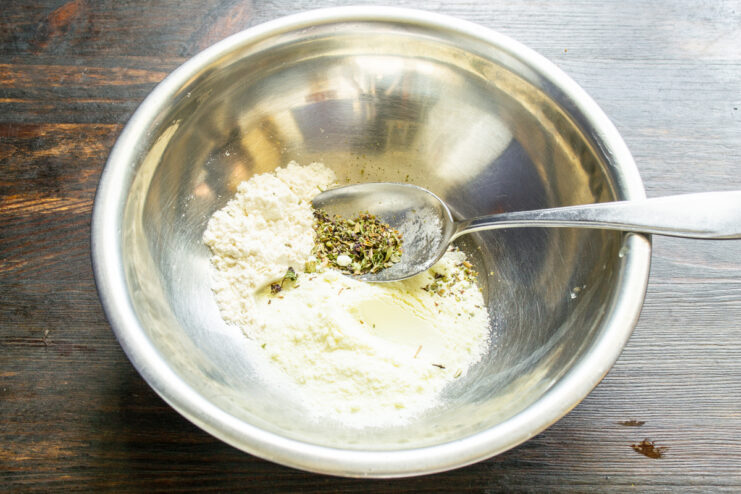 Mezcla de ingredientes secos Mezclando harina, leche en polvo y hierbas provenzales en un tazón