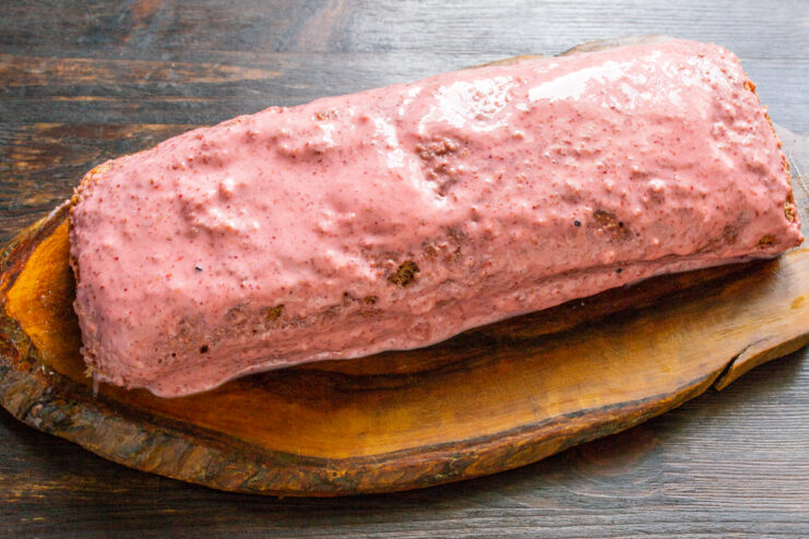 Cobertura del rollo de bizcocho con crema Rollo de bizcocho cubierto con crema de fresa rosa
