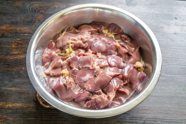 Hígado de pollo crudo en un tazón metálico preparado para ser procesado por el molino.