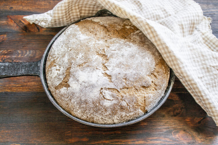 Masa dentro del molde cubierta con una toalla de cocina limpia