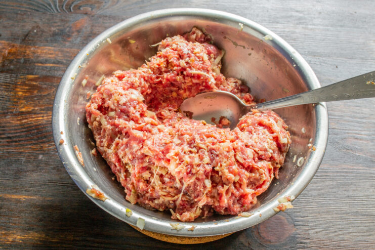 Amasado manual de la mezcla de carne en un tazón