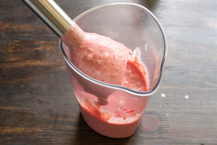 Proceso de preparación de la crema de fresa Batido de la crema de fresa con una batidora de inmersión