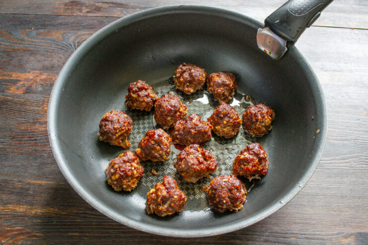 Albóndigas dorándose en una sartén con aceite caliente